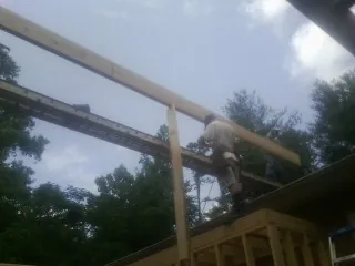 Carpenter setting a ridge beam over a new addition frame — Ice Dam Removal by Roofing Brothers in Kintnersville