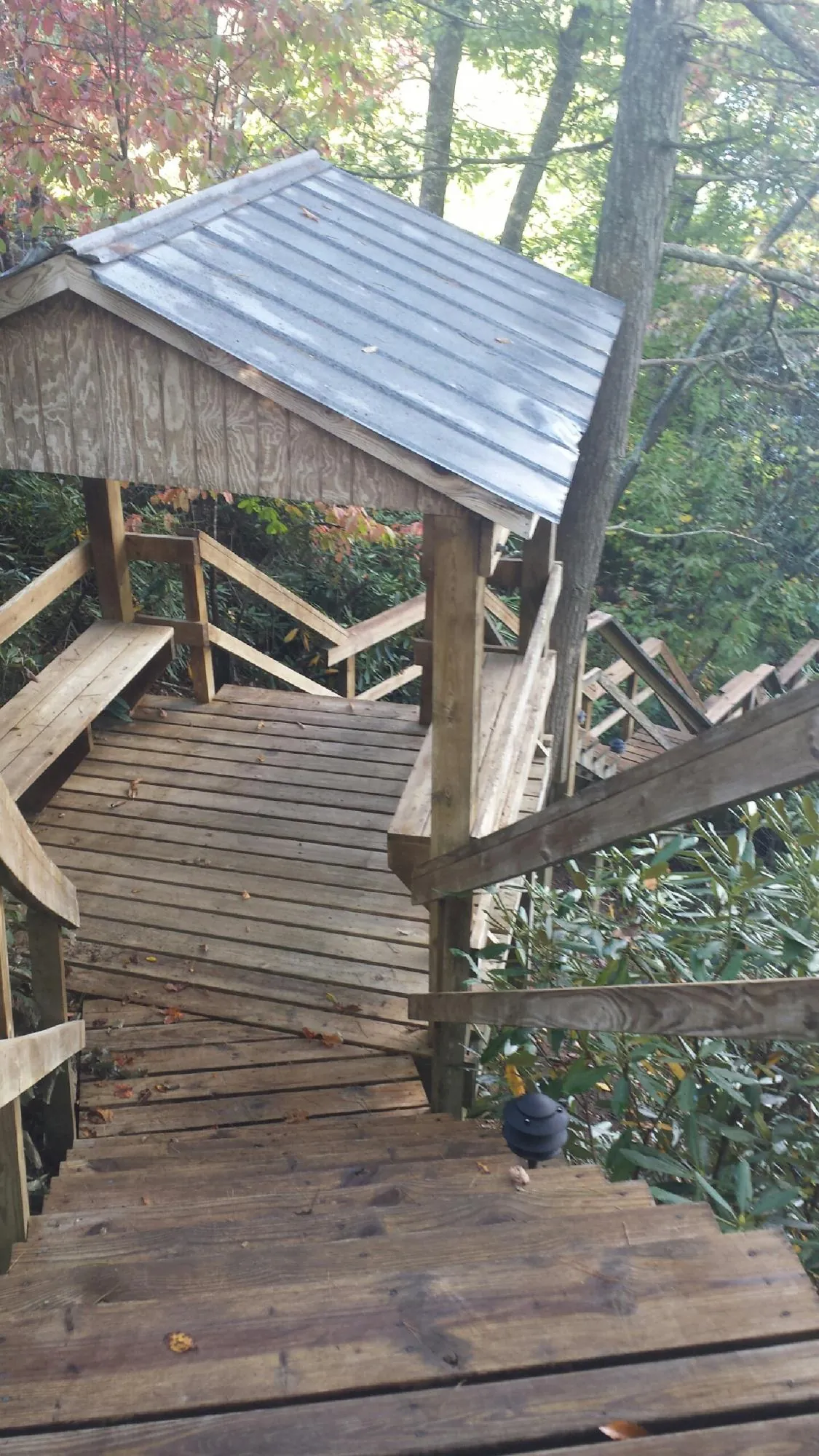Metal roofed shelter over wooden steps on a wooded walkway — Skylight Repair & Installation work by our crew in Kintnersville