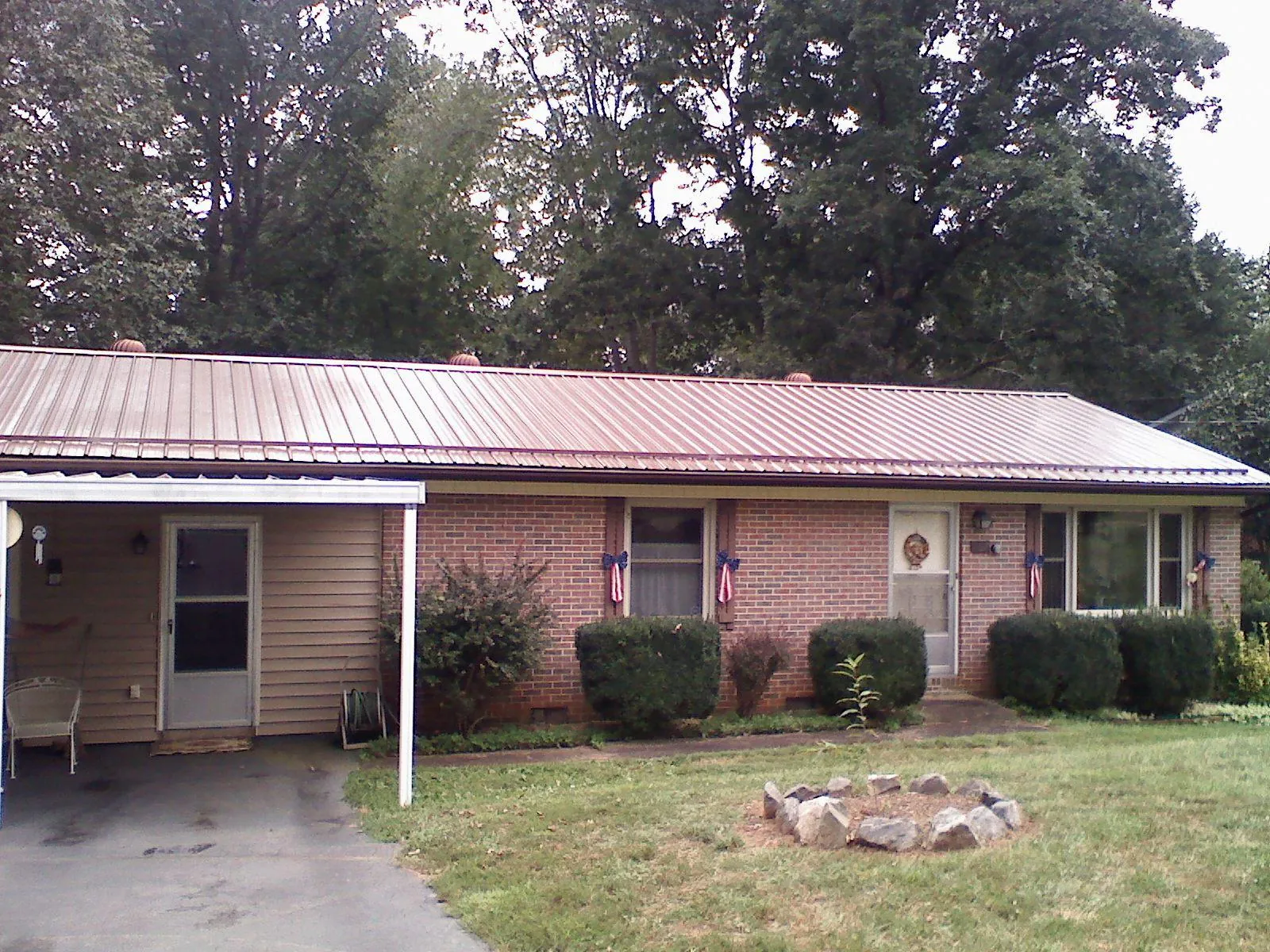 Bronze metal roof and carport on a brick ranch home — Roof Repair work by our crew in Kintnersville